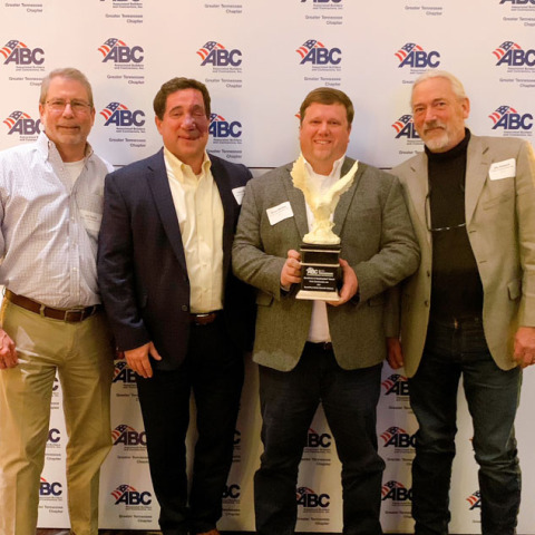 Crain leaders holding Eagle Award trophy