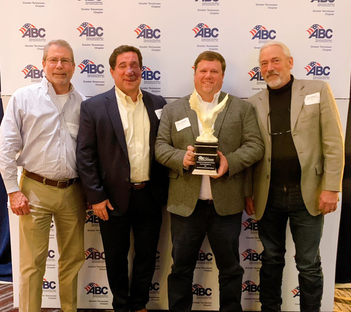 Crain leaders holding Eagle Award trophy