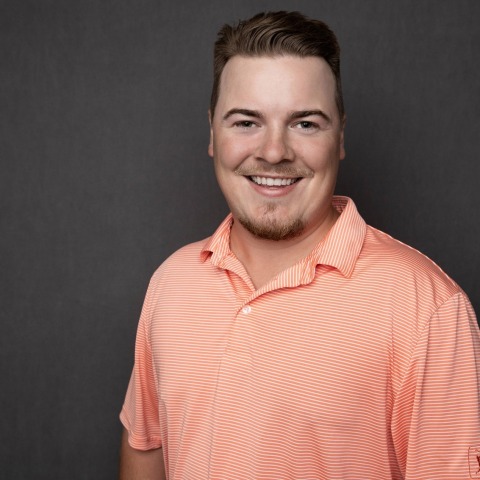 professional portrait of Scott Ellis smiling in an orange polo