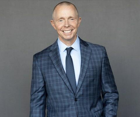 Professional portrait of Micheal Rankin smiling in a suit