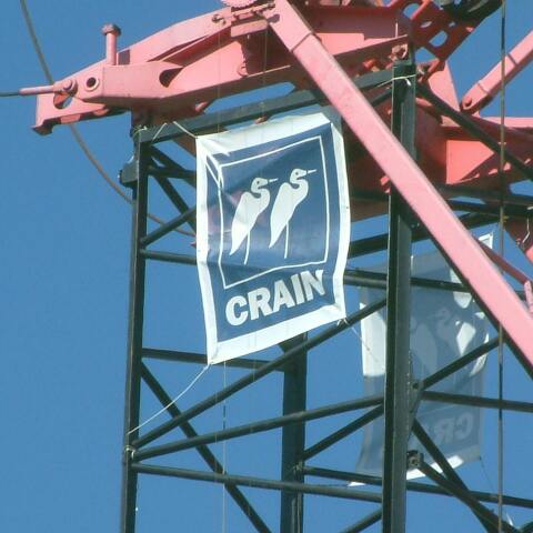 Crain Construction banner waving in the wind off scaffolding in the sky