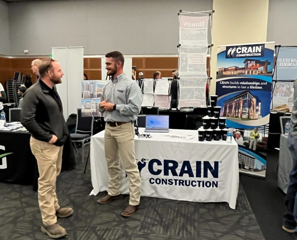 Spencer Rankin is standing in front of the Crain Construction booth at the MTSU Career Fair