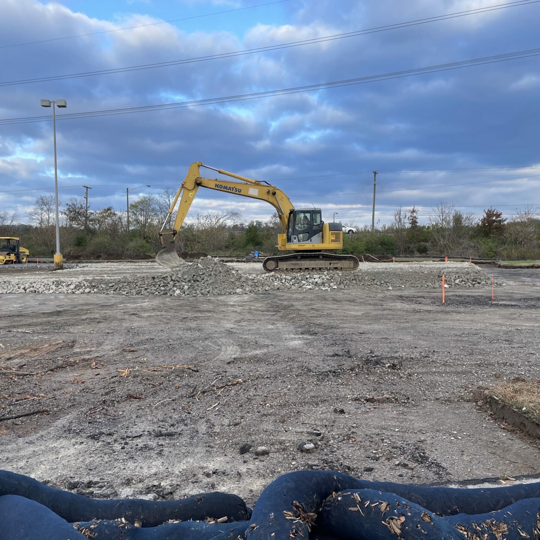 An excavator scooping gravel on a construction site.