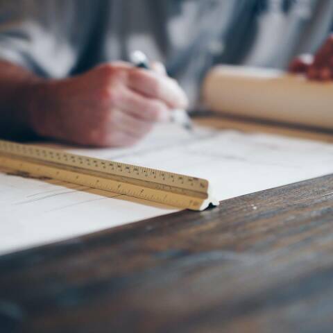 man looking at construction plans on a wood table