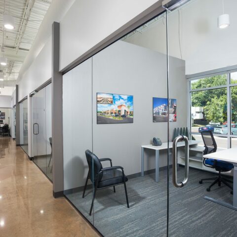 Inside of the Crain Construction Office, featuring all-glass doors and exposed ceilings.