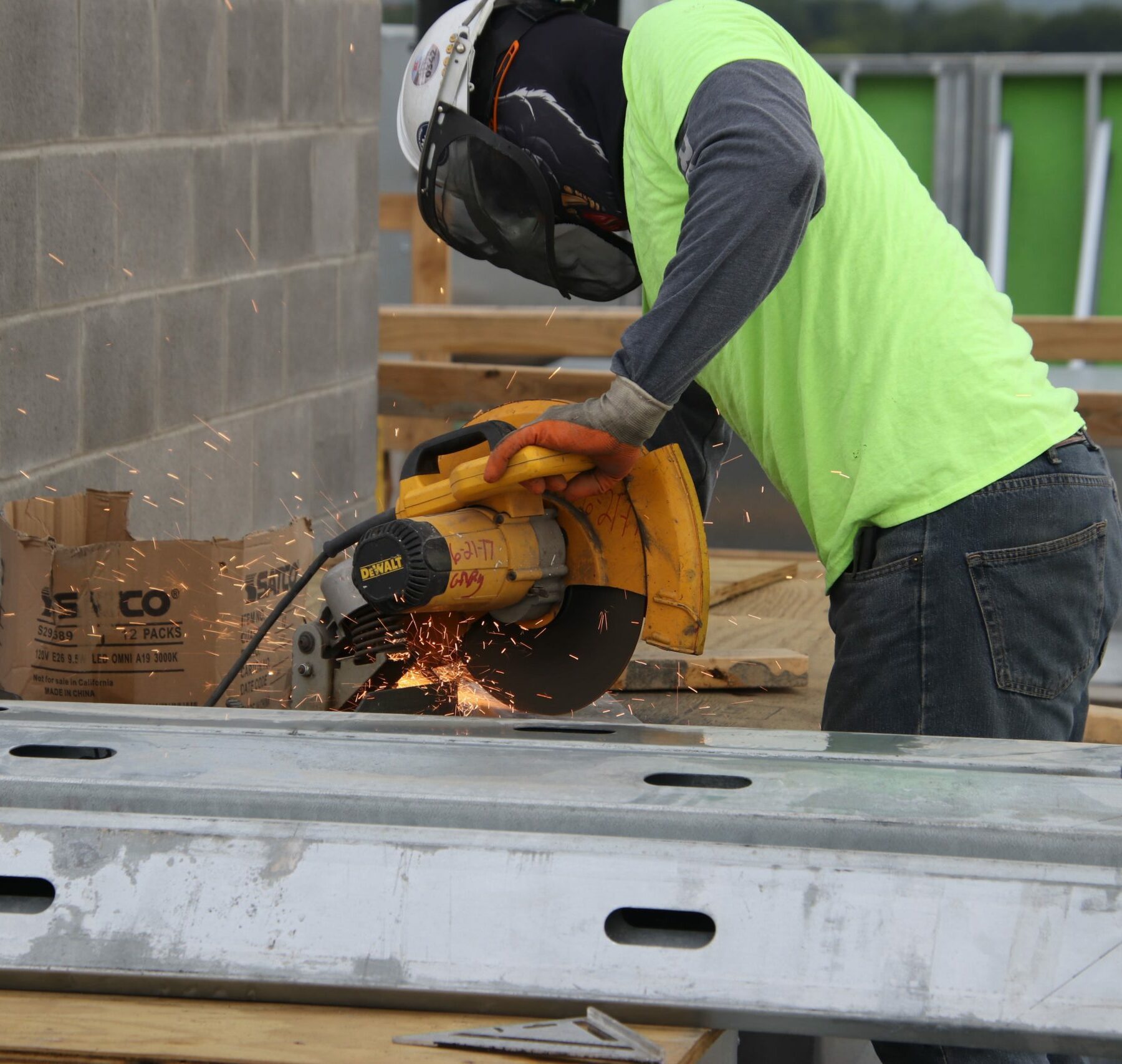 construction worker in safety gear using a table saw