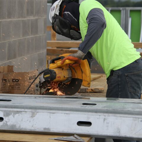 construction worker in safety gear using a table saw