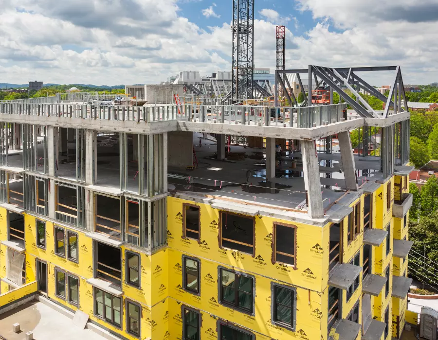 Building under construction with yellow house wrap