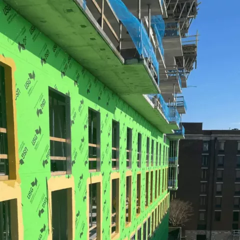 commercial building wrapped in green house wrap under construction