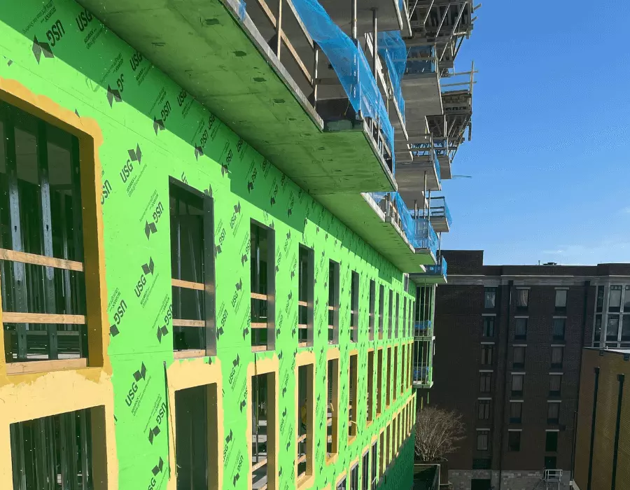 commercial building wrapped in green house wrap under construction
