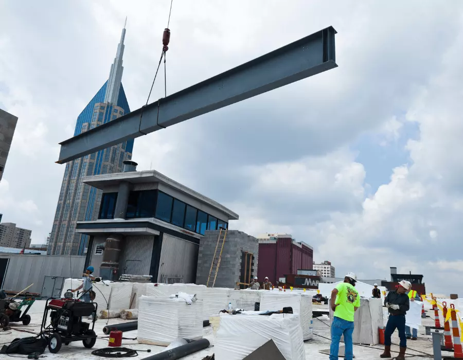 A crain placing building materials on the roof of Acme Food and Supply.