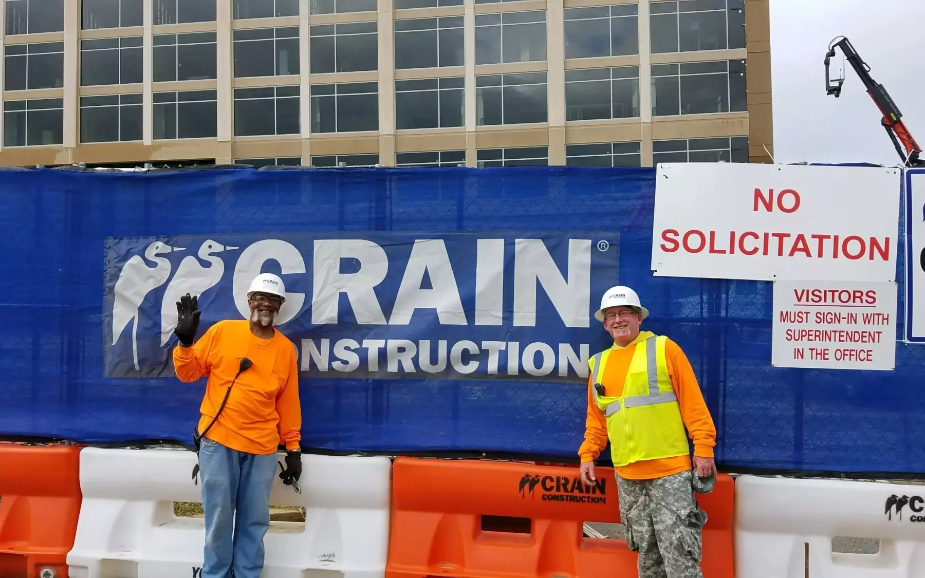 two construction workers posing in front of commercial construction project